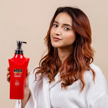 A Model holding a bottle of hair fall control shampoo